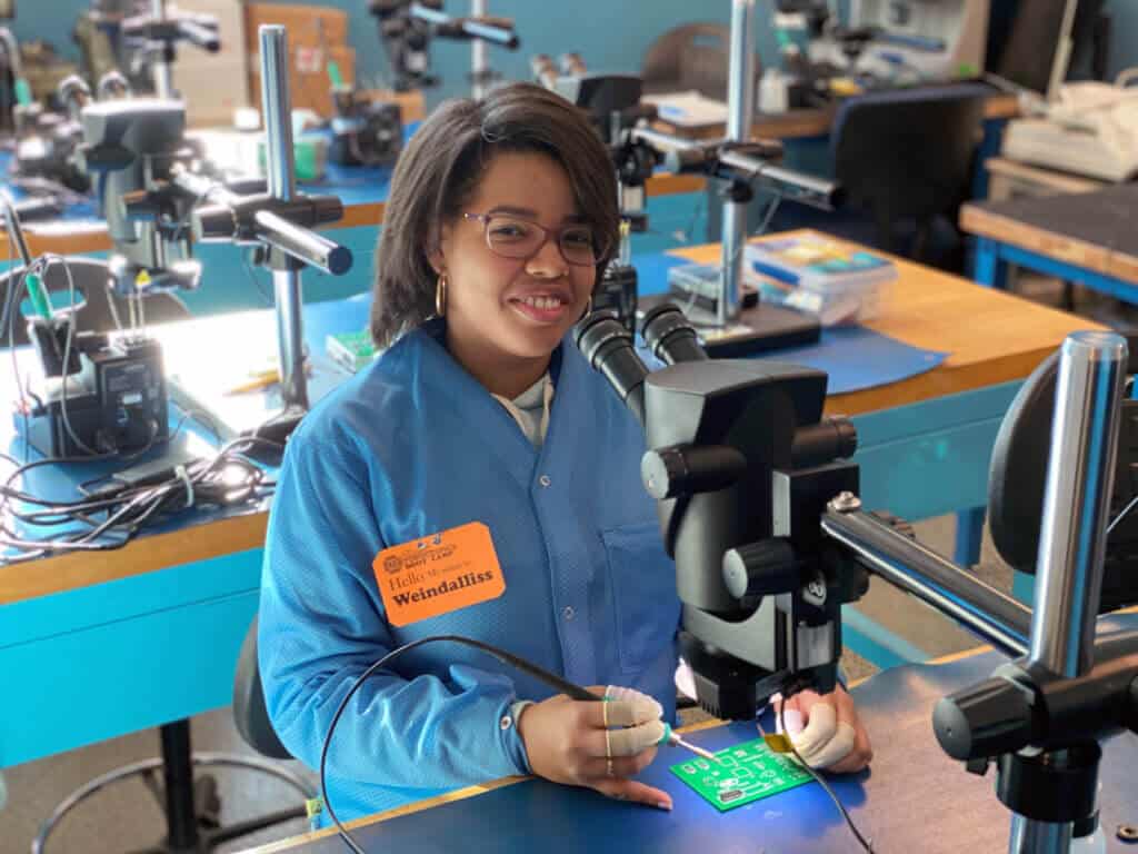 A student working at the soldering lab station at Nashua Community College