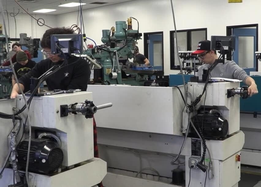 students operating machines in the Precision Manufacturing lab at Nashua Community College